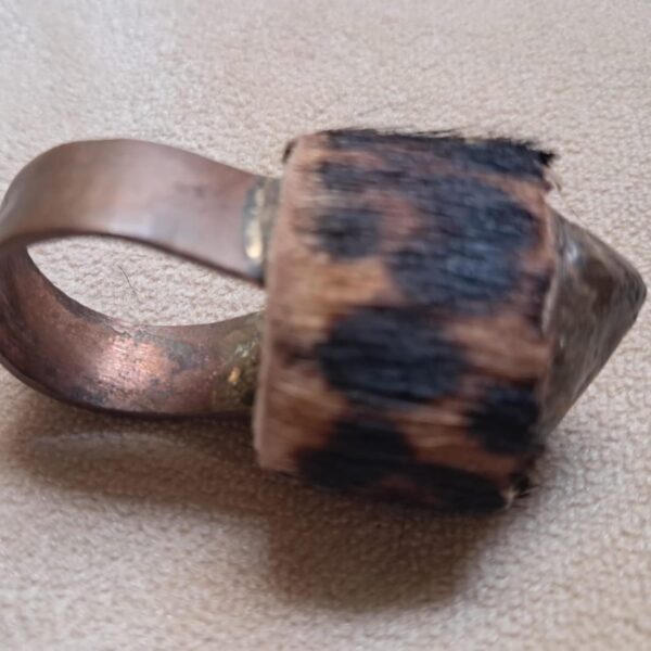 A ring featuring a wide, smooth copper band attached to a cylindrical centerpiece covered in brown and black leopard-print fur. The centerpiece terminates in a pointed, metallic, copper-toned tip, creating a distinct contrast. — Khodamdjin